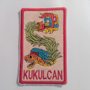 May include: A red, white, and green embroidered patch with a stylized image of a serpent with the word "KUKULCAN" below it.