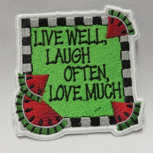 May include: Green embroidered patch with a white border and black and white checkered trim. The patch features watermelon slices and the text "Live Well, Laugh Often, Love Much."