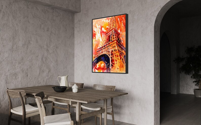 May include: A watercolor painting of the Eiffel Tower in Paris, France. The painting is in shades of orange, yellow, and red, with a blue sky in the background. The painting is framed in a black frame and is hanging on a wall in a dining room.