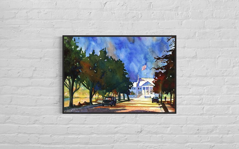 May include: Watercolor painting of a white building with columns and an American flag, framed in black. The artwork depicts a street scene with trees, cars, and a blue sky.