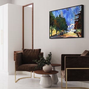 May include: An interior scene featuring two brown armchairs with gold frames, a framed watercolor painting of a street scene, and two small side tables. The room has white walls and a white tiled floor. A tall white cabinet and a dark wood-framed mirror are also visible.