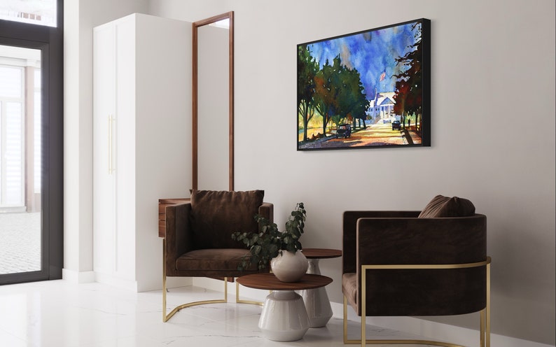 May include: An interior scene featuring two brown armchairs with gold frames, a framed watercolor painting of a street scene, and two small side tables. The room has white walls and a white tiled floor. A tall white cabinet and a dark wood-framed mirror are also visible.