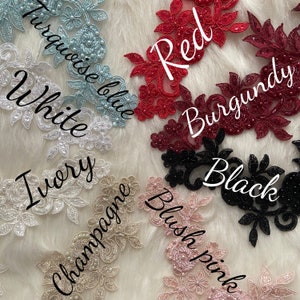 May include: Assortment of lace trim in various colors, including white, ivory, champagne, blush pink, turquoise blue, red, burgundy, and black. Each trim features a delicate floral design with pearl embellishments.