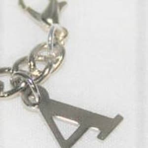 May include: Silver charm with a letter A pendant attached to a silver chain with a lobster clasp.