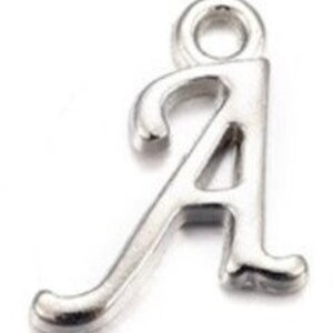 May include: Silver charm in the shape of the letter A. The letter is in a cursive style with a loop at the top for attaching to a chain or bracelet.