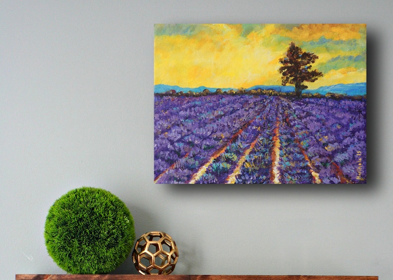 Puede incluir: Una pintura de un campo de lavanda con un solo &aacute;rbol en el centro. El cielo es de un amarillo brillante con algunas nubes. El campo es de un morado vibrante con filas de plantas de lavanda.