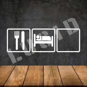 May include: Three white square signs with black outlines on a gray textured background. The signs have simple icons: a fork and knife, a bed with a person sleeping in it, and a blank square. A wooden table is in the foreground.