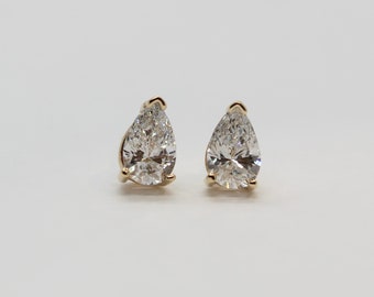 May include: A pair of pear-shaped diamond earrings set in gold.