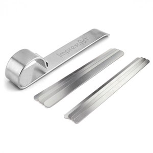 May include: A set of silver metal tools for making impressions in clay. The set includes a ring-shaped tool and five straight tools of varying lengths. The tools are labelled "ImpressArt".