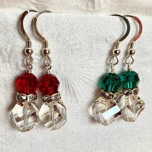 May include: Dangle earrings with silver hooks. One pair features red and clear crystal beads, the other green and clear. The earrings have a festive, elegant design, perfect for special occasions.