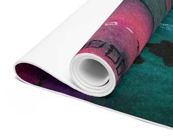 May include: A rolled up yoga mat with a colorful abstract design featuring shades of pink, purple, green, and black. The mat has a white backing.