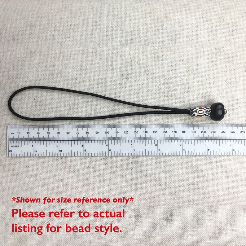 May include: Black elastic cord with a black and white patterned bead and a brown wooden bead. The cord is 20 inches long. *Shown for size reference only* Please refer to actual listing for bead style.