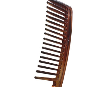 May include: A brown plastic comb with a wide handle and fine teeth.