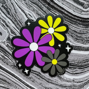 May include: A sticker with three stylized flowers in purple, yellow, and gray with white centers. The flowers are on a black background with white stars.
