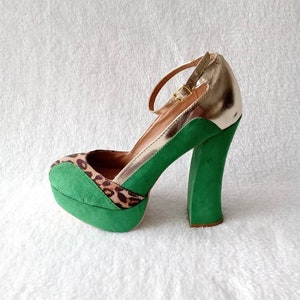 May include: Green platform heels with a gold ankle strap and leopard print detail.