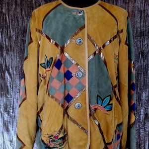 Peut inclure: Une veste en daim marron avec un motif patchwork composé de formes géométriques et de broderies florales. La veste a une fermeture à boutons et un col.