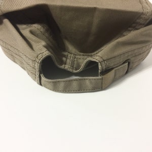 May include: A brown canvas baseball cap with an adjustable strap in the back.