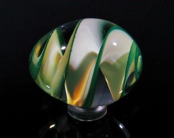 May include: A glass marble with swirling patterns of green, white and yellow.