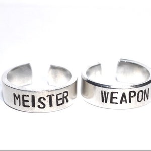 May include: Two silver rings with the words "MEISTER" and "WEAPON" engraved on them.