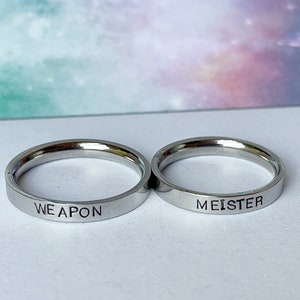 May include: Two silver rings with the words "WEAPON" and "MEISTER" engraved on them.