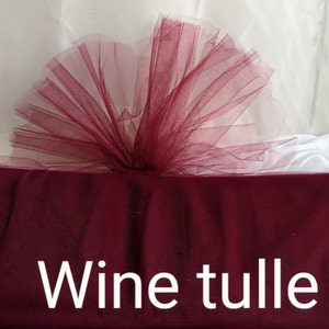 May include: Wine colored tulle fabric. The tulle is soft and sheer, with a delicate texture.  The fabric is perfect for crafting, decorating, and adding a touch of elegance to any project.