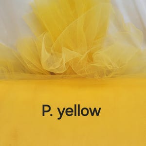 May include: Bright yellow tulle fabric, with a fine mesh texture, is gathered and layered. The fabric is a solid, vibrant yellow color, with the text "P. yellow" in black, centered at the bottom. The fabric is likely used for crafting or decorative purposes.