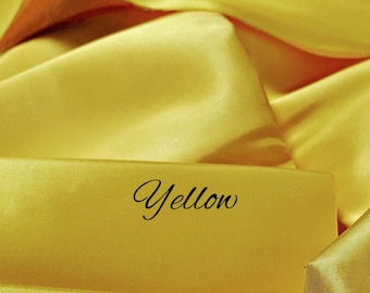 May include: Close-up of a smooth, yellow fabric with the word "Yellow" written in black.