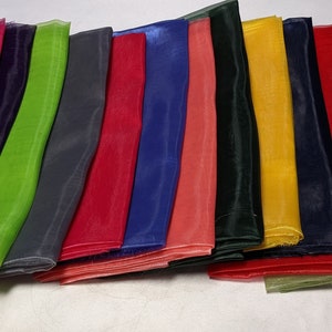May include: A collection of 14 sheer fabric swatches in various colors, including teal, pink, green, gray, red, blue, orange, yellow, black, and brown.