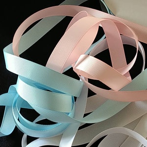 May include: A collection of pastel colored ribbon in pink, light blue, and white. The ribbon is woven with a textured pattern.