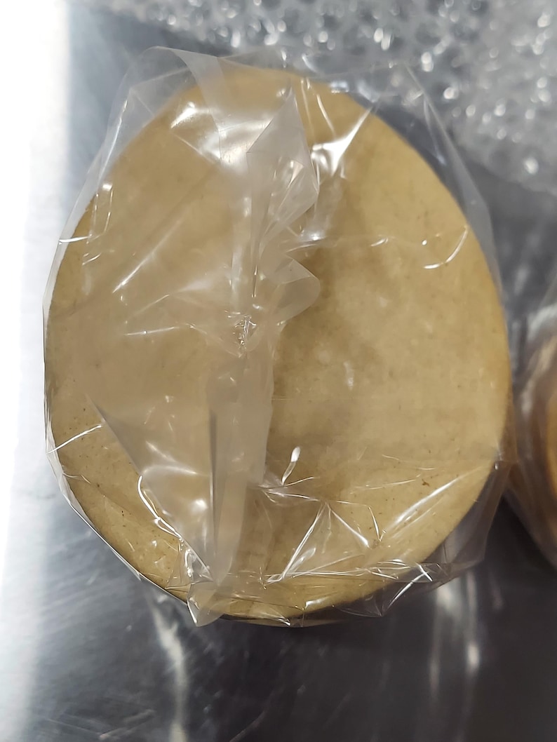 May include: A single, round, light brown tortilla wrapped in clear plastic.