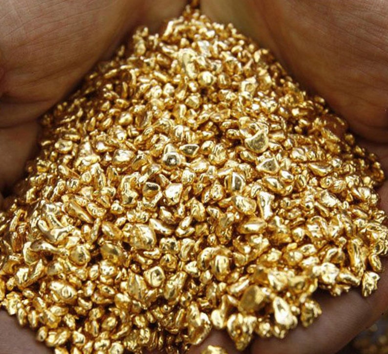 K&ouml;nnte beinhalten: Nahaufnahme eines Haufens Goldnuggets. Die Nuggets sind in verschiedenen Gr&ouml;&szlig;en und Formen und alle gl&auml;nzend und golden.