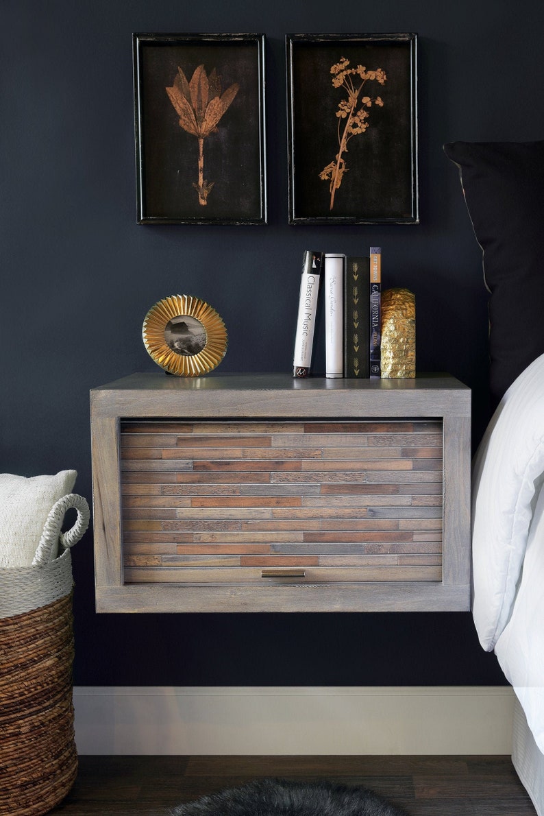 A dark grey wall with a modern grey wall mounted night stand