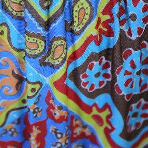 K&ouml;nnte beinhalten: Nahaufnahme eines bunten Stoffes mit Paisley-Muster. Der Stoff ist blau, rot, gr&uuml;n, gelb und braun. Das Muster ist kompliziert und detailliert.