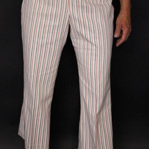 May include: White pants with red and blue vertical stripes. The pants have a wide leg and are cropped above the ankle.