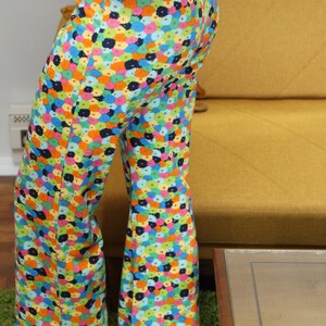May include: A pair of wide-legged pants with a colorful floral print. The pants are made of a lightweight fabric and have a relaxed fit.
