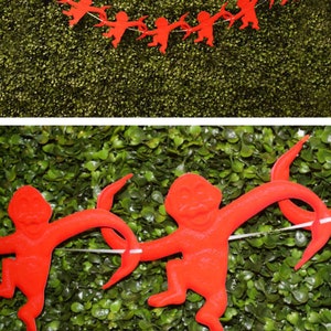 K&ouml;nnte beinhalten: Rote Papier-Affen-Ausschnitte, die zu einer Girlande zusammengef&uuml;gt sind. Die Girlande h&auml;ngt vor einem gr&uuml;nen Hintergrund. Der Text "Creative Touch" und eine Website-Adresse sind unten im Bild sichtbar.