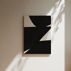Op de afbeelding: Abstracte kunstprint met zwarte en witte geometrische vormen. De print heeft een zwarte achtergrond met witte driehoeken en een gebogen vorm.