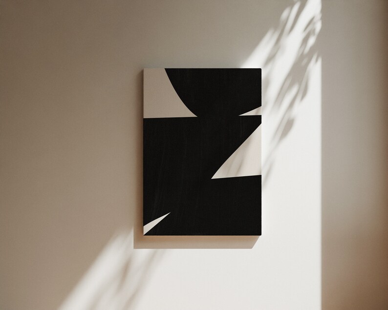 Op de afbeelding: Abstracte kunstprint met zwarte en witte geometrische vormen. De print heeft een zwarte achtergrond met witte driehoeken en een gebogen vorm.