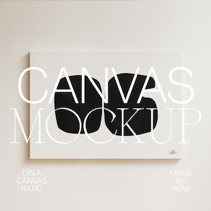 Könnte beinhalten: Ein weißer Leinwand-Mockup mit dem Text "CANVAS MOCKUP" in schwarzen Buchstaben. Die Leinwand hängt an einer weißen Wand.
