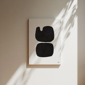 Op de afbeelding: Een zwart-witte abstracte kunstprint met twee overlappende vormen. De print is op een wit canvas en heeft een eenvoudige, moderne esthetiek.
