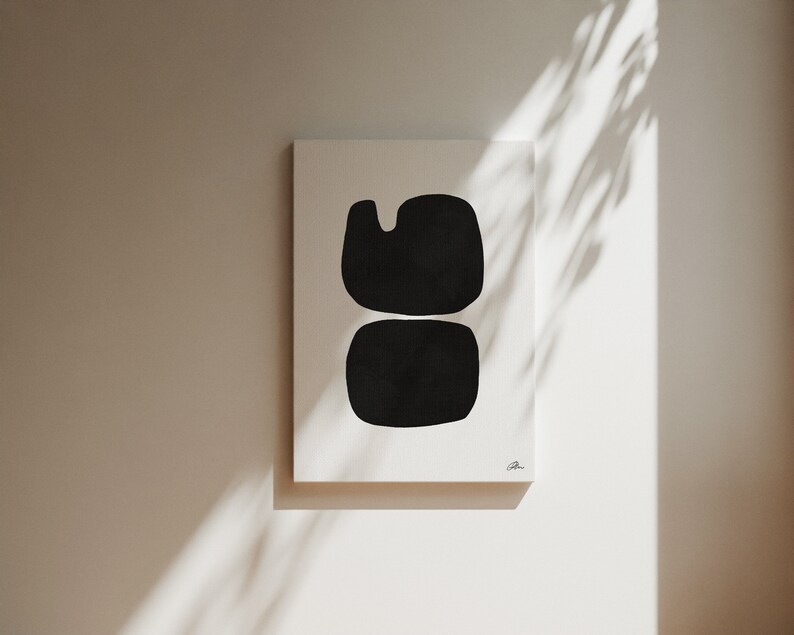 Op de afbeelding: Een zwart-witte abstracte kunstprint met twee overlappende vormen. De print is op een wit canvas en heeft een eenvoudige, moderne esthetiek.