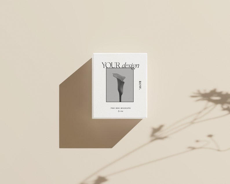 Pu&ograve; includere: Mockup di scatola bianca con una foto in bianco e nero di un fiore e il testo "YOUR design ROW." La scatola &egrave; su uno sfondo beige.