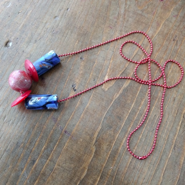 collier de perles bleu et rouge et boutons rouge montés sur un lien rouge