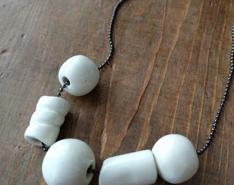 collier de perles blanches montées sur un lien noir