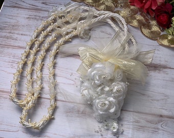 Puede incluir: Una cuerda de ceremonia de boda blanca y marfil con un lazo de satén blanco y un ramo de flores de seda blancas.