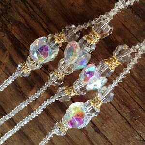 May include: Three strands of clear crystal beaded necklaces with iridescent glass beads and gold accents.