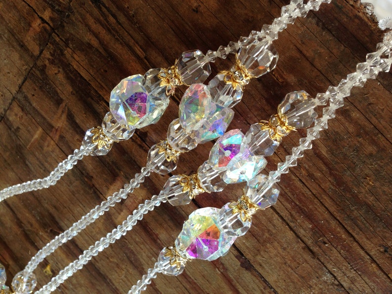 May include: Three strands of clear crystal beaded necklaces with iridescent glass beads and gold accents.