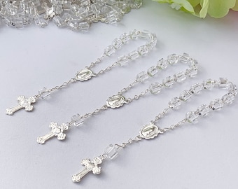 Peut inclure: Trois chapelets en argent et en cristal avec une croix et un charme de la Vierge Marie. Chaque chapelet a des perles de cristal claires.
