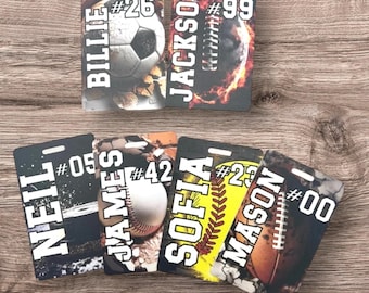 Könnte beinhalten: Sechs personalisierte Sport-Namensschilder mit verschiedenen Sport-Hintergründen. Die Schilder zeigen Namen wie Billie, Jackson, Neil, James, Sofia und Mason mit entsprechenden Nummern.