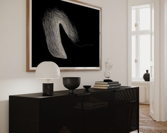 May include: A black metal cabinet with a wire mesh front and two doors. The cabinet is sitting on a wooden floor and has a white lamp, a black bowl, and a stack of books on top of it. A framed black and white abstract art print hangs on the wall behind the cabinet.
